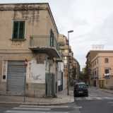 ...e a destra un caseggiato su cui � ben visibile una scritta risalente al Ventennio fascista. La palazzina fa angolo con via Carafa...